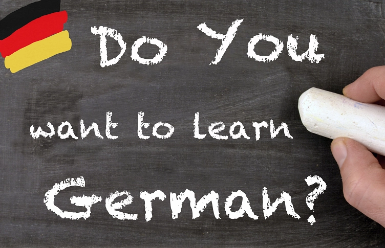 Kreidetafel mit Hand mit Kreide in der Hand, auf der steht Do you want to lern German? © Sinuswelle, stock.adobe.com
